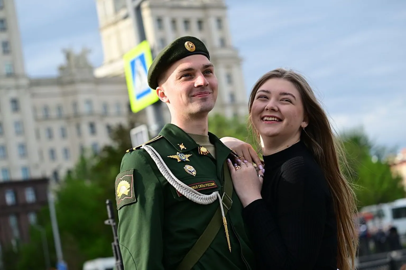Anadolu via A Russian soldier poses for a photo with a woman in Moscow's Red Square.
