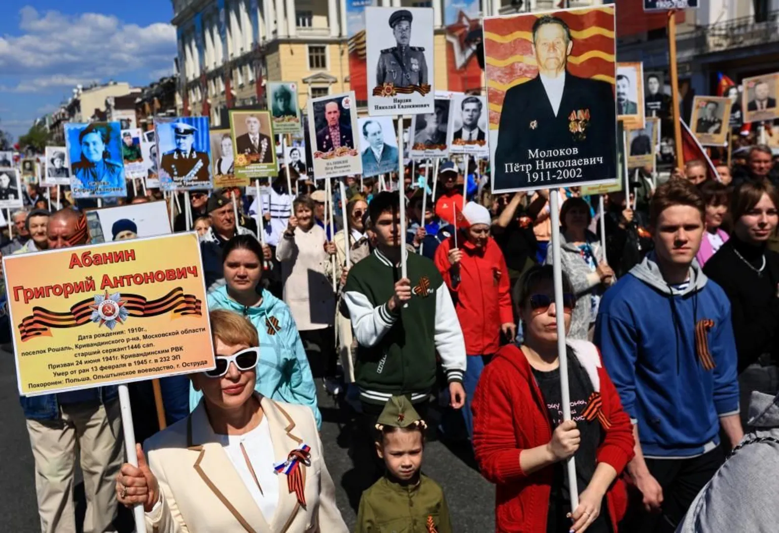  Crowds of people march along a road carrying placards featuring pictures of soldiers and veterans during an Immortal Regiment march in Vladivostok.