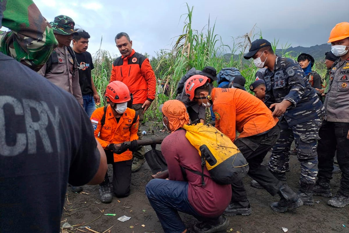Rescuers carry the body of a victim of the eruption of Mount Dukono, Saturday, 9 May.