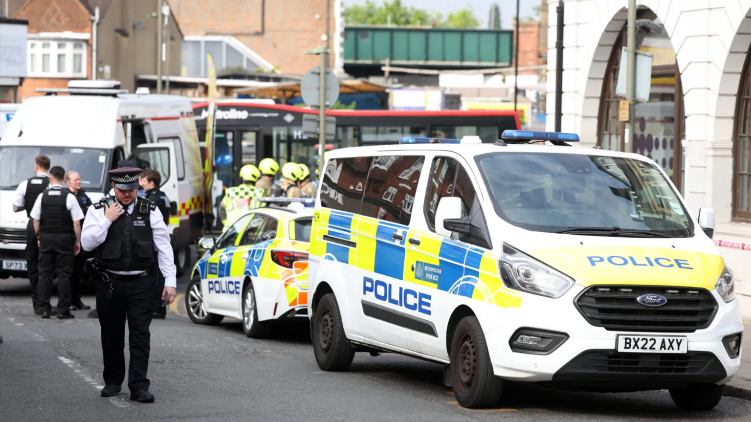  Police and ambulance cars parked on the street with the Natwest bank on the righthand side. 