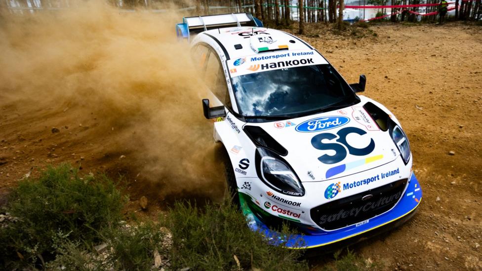 The white and blue M-Sport Ford Puma of Jon Armstrong throws up dust on Rally de Portugal