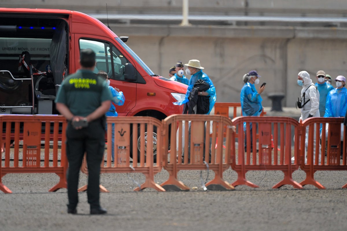 People board military buses after being evacuated from the hantavirus-stricken cruise ship MV Hondius at the port of Granadilla de Abona on the island of Tenerife.