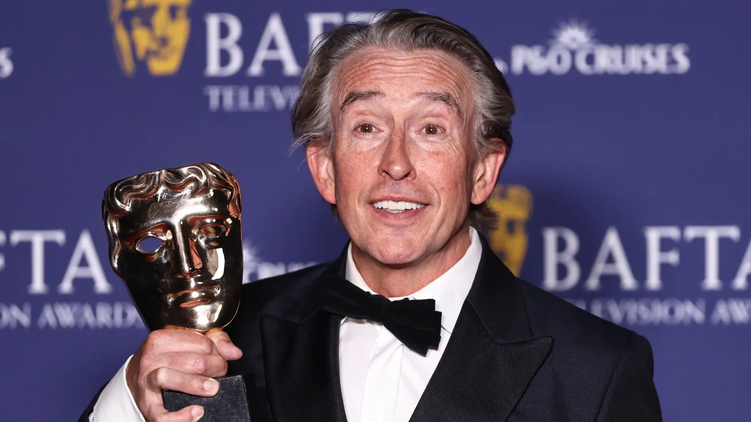 EPA Steve Coogan holding his Bafta trophy