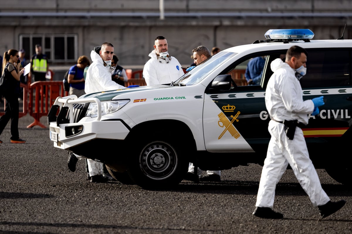 People in hazmat suits near a Guardia Civil car