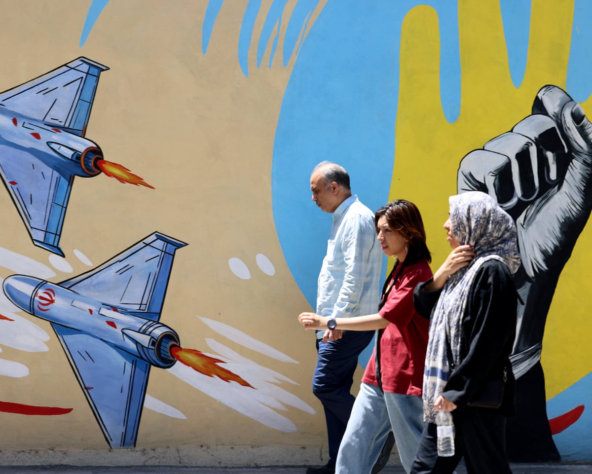 Iranians walk past an anti-US and anti-Israel mural painted on a wall in Tehran on Sunday