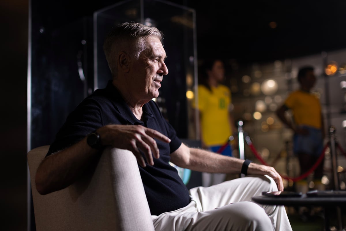 Carlo Ancelotti poses for a photo in a trophy room