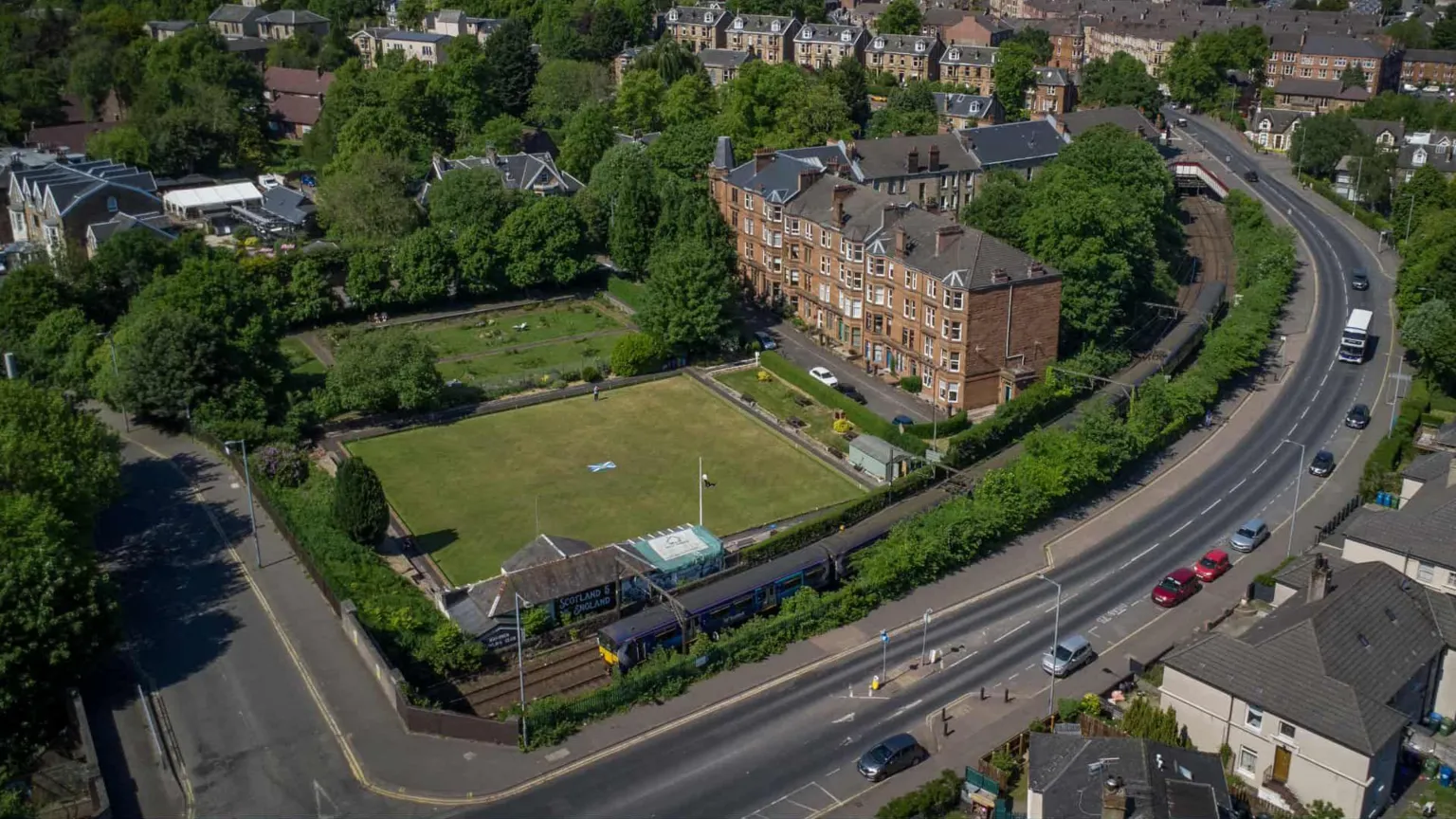 Campbell Ramage An aerial view of a bowling green with a block of flats and a road running alongside it.