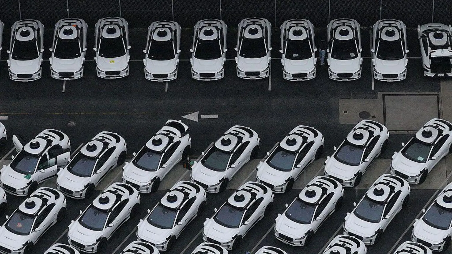 An overhead view of a fleet of white Waymo vehicles