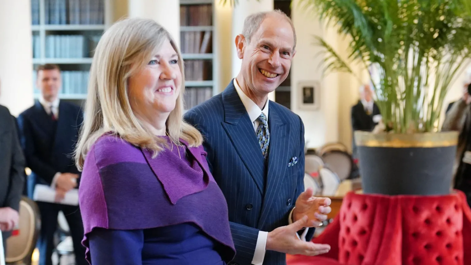 smiling woman with blonde hair next to a smiling balding man