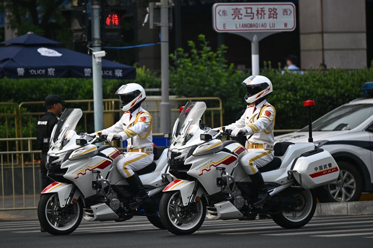 Motor unit police officers ride around the perimeter of the hotel where Donald Trump is staying in Beijing.