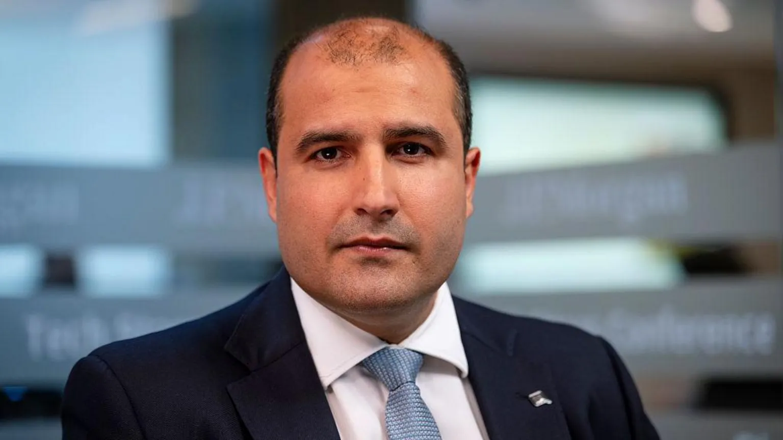 Bloomberg via Vishal Marria, Quantexa's chief executive, looks at the camera, wearing a dark suit, white shirt and light blue tie.