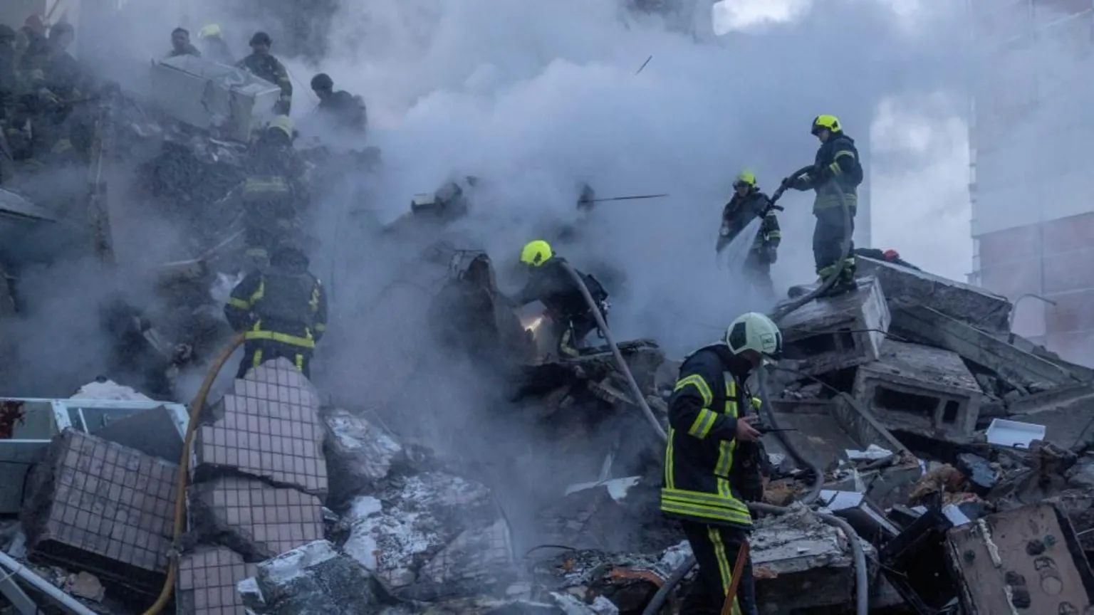 Emergency service workers search a smouldering building
