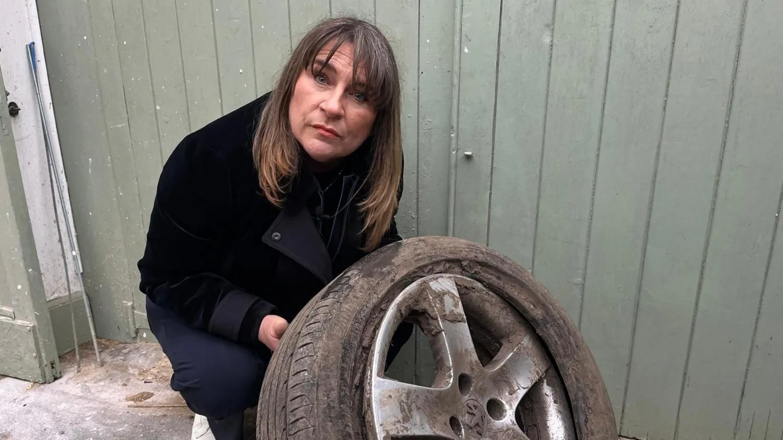 Sarah Gray pictured holding a burst tyre.