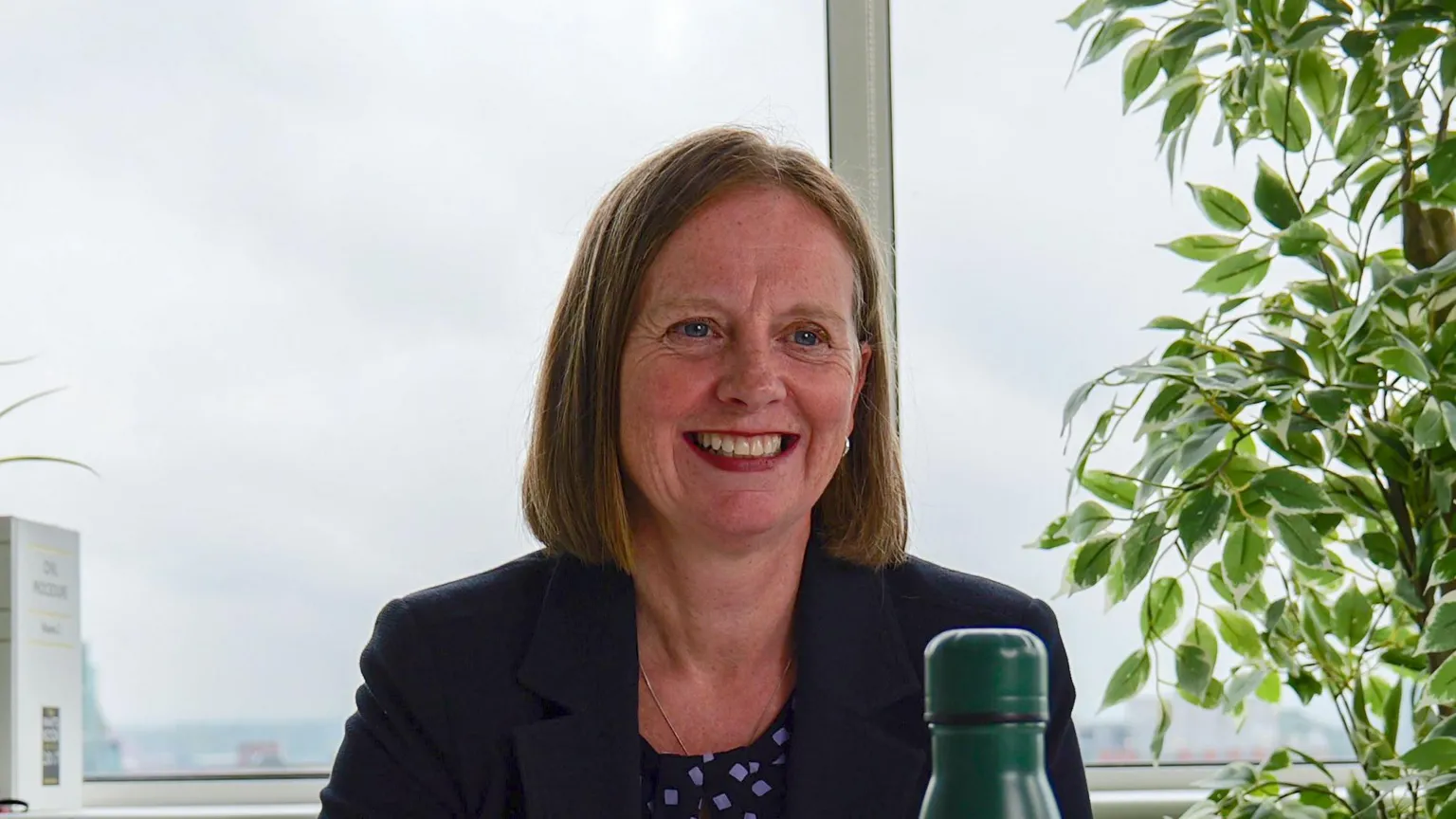 Fletchers A woman wearing a blazer and holding a pen.