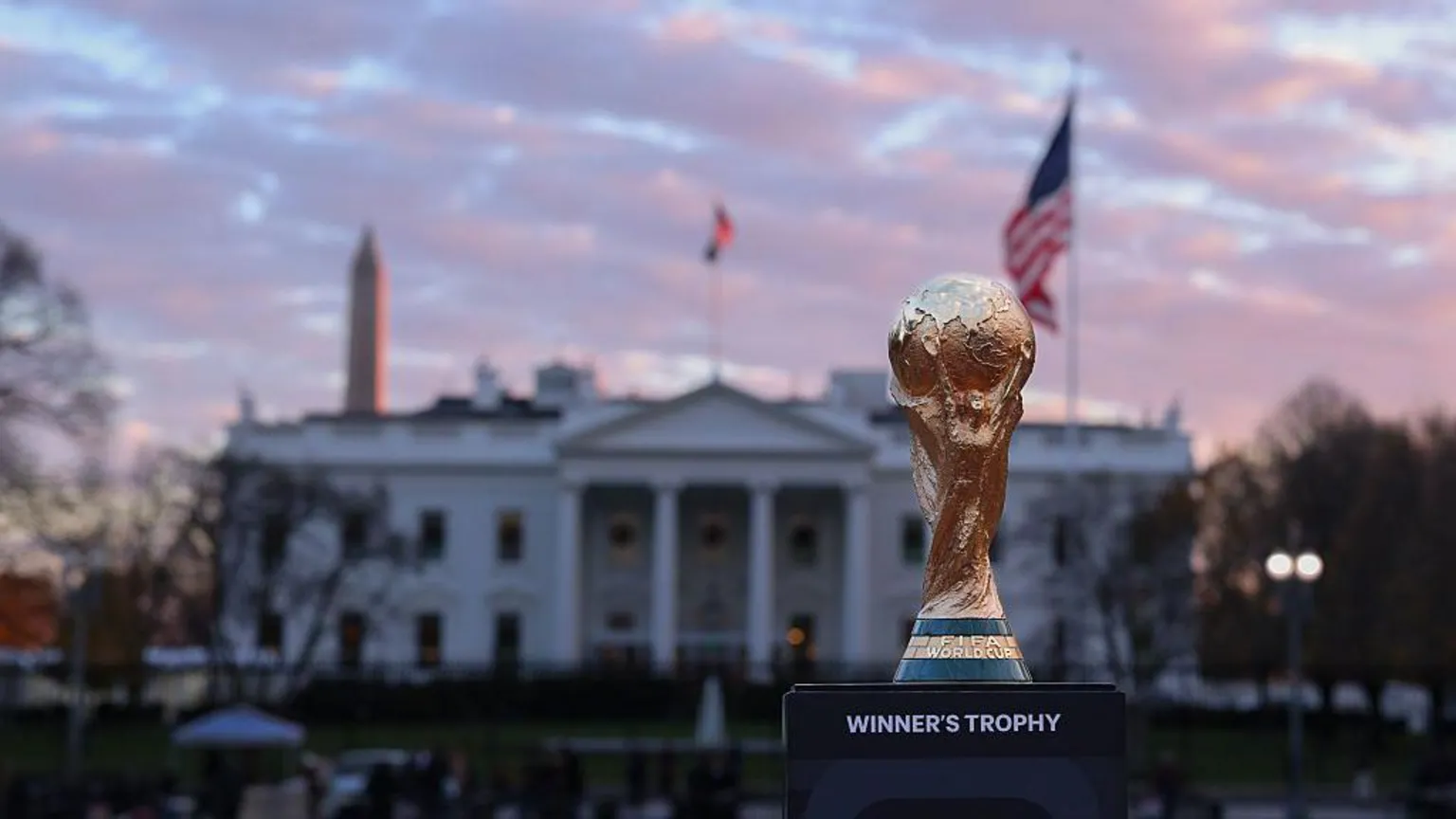  The World Cup trophy sits in front of the White House with a USA flag and the Washington Monument either side of it. 