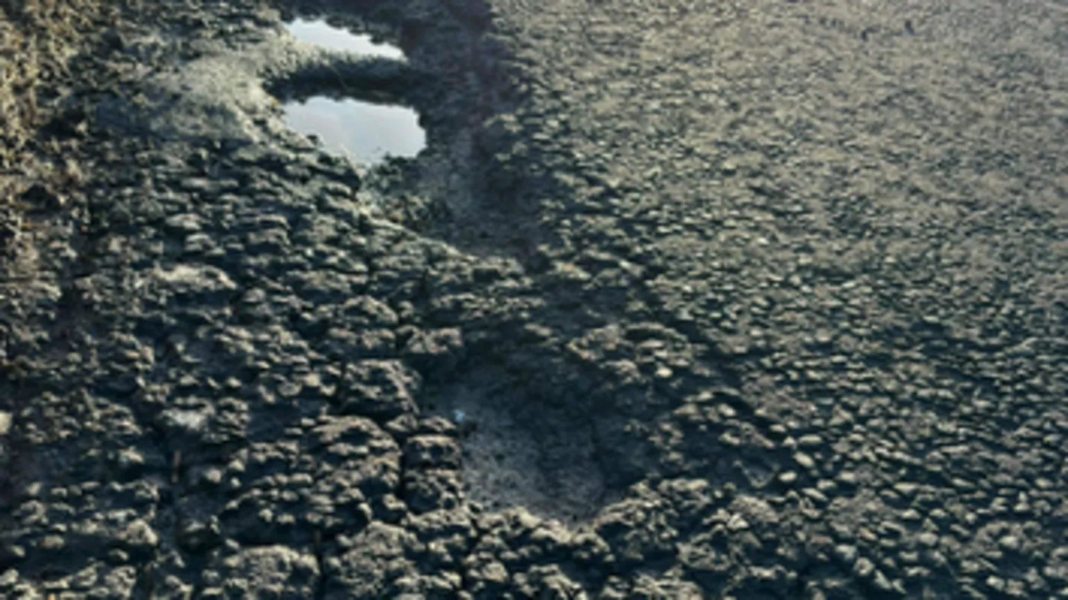 Marie McCallum Deep potholes on a road