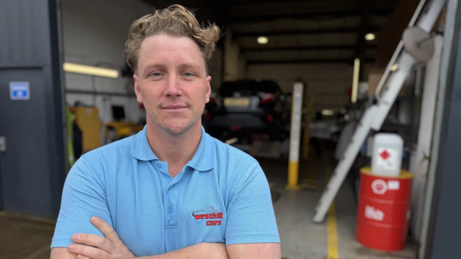 Lewis Mennie from Westhill Cars is standing at his garage 