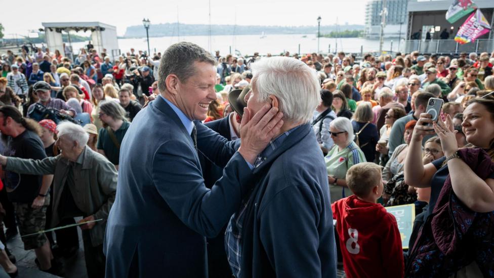 Rhun ap Iorwerth a'i dad Edward Morus Jones yn cael sgwrs siriol o flaen torf o gefnogwyr o flaen y Senedd ddydd Sadwrn diwethaf