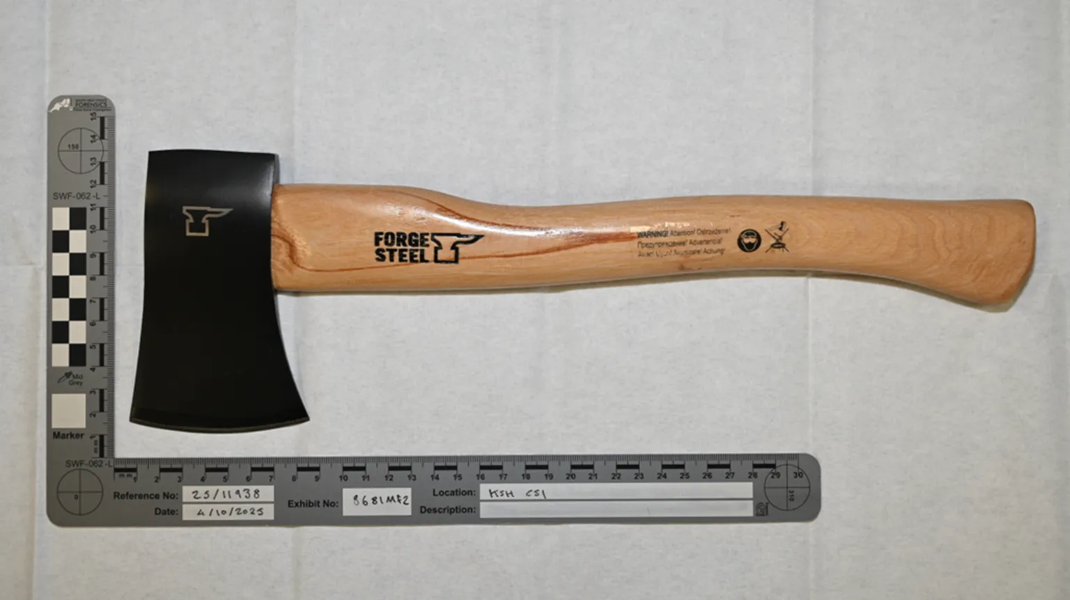 Counter Terrorism Police An axe is led on a surface against a ruler to measure the width and length of the tool.