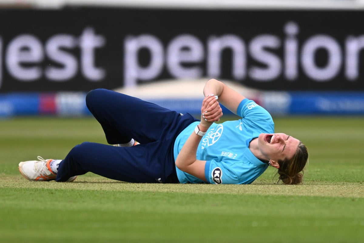 England’s Lauren Bell holds her hand while laying on the floor after trying to take a return catch