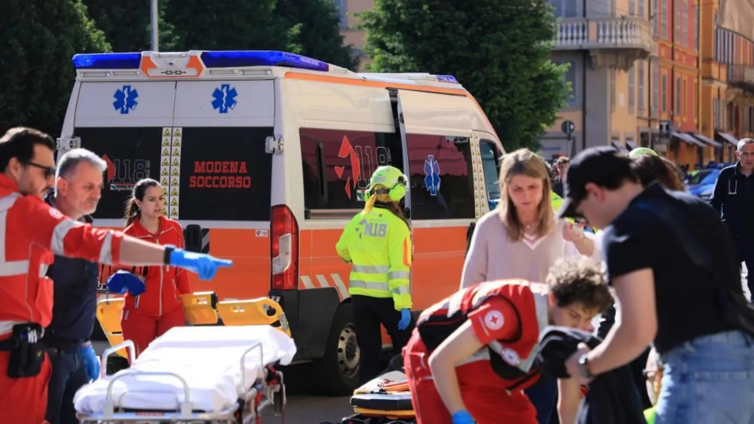 EPA Paramedics in red uniforms attend to injured people, an ambulance can bee seen as well as a stretcher in addition to civilians