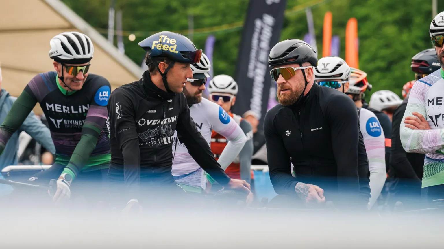 Red On Sports Three men dressed in black on bikes including Bradley Wiggins who has a big ginger beard and sunglasses on and a black helmet
