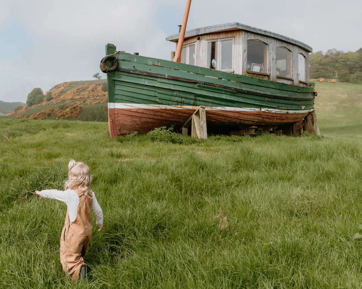 boat in a field and young child pointing
