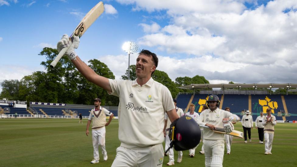 Ryan Hadley raises his bat as he walks off followed by Glamorgan team-mates