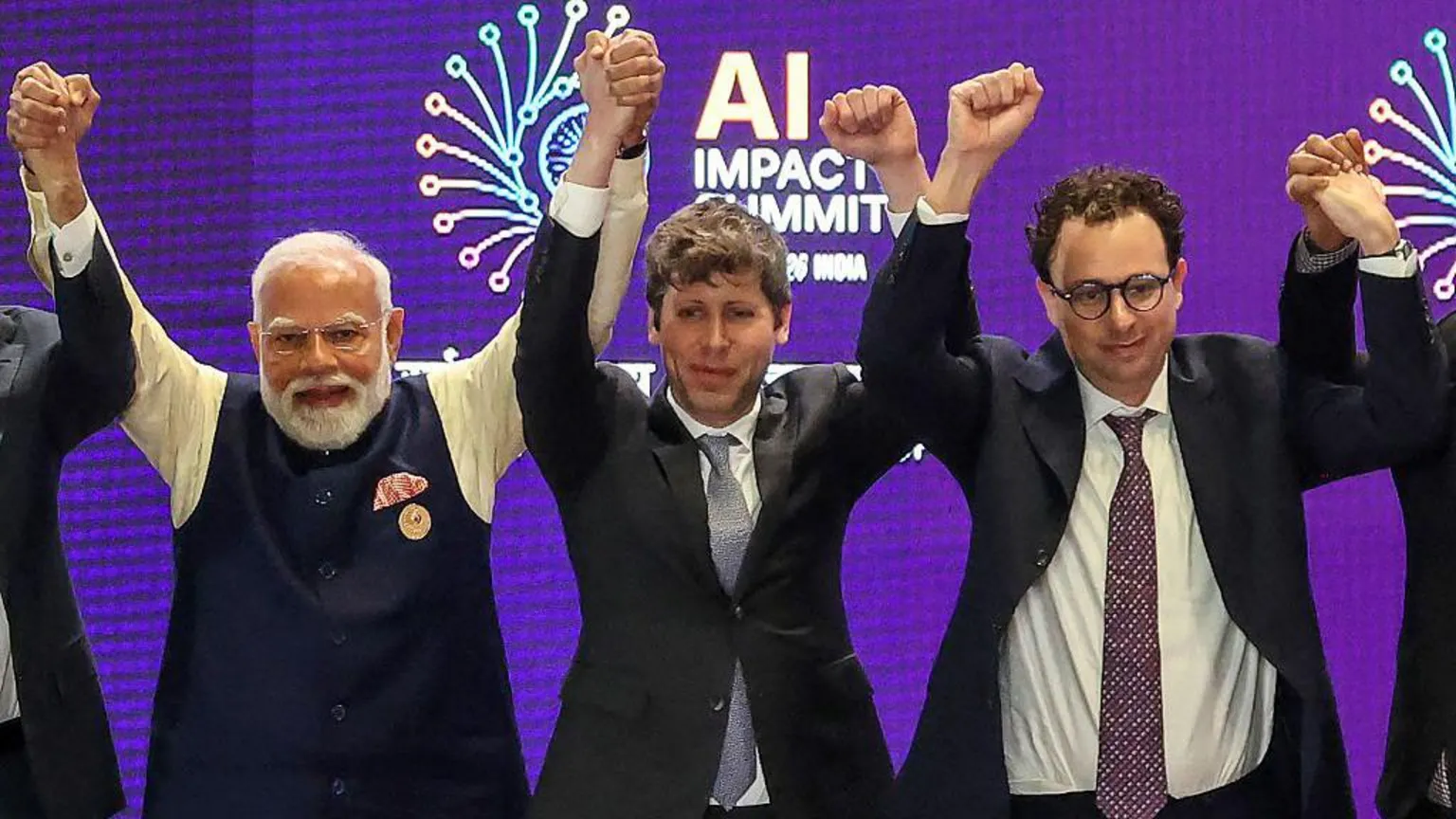AFP via India's Prime Minister Narendra Modi stands beside Sam Altman and Dario Amodei, shown clenching their fists instead of holding each other's hands, at the AI Impact Summit in New Delhi in February.