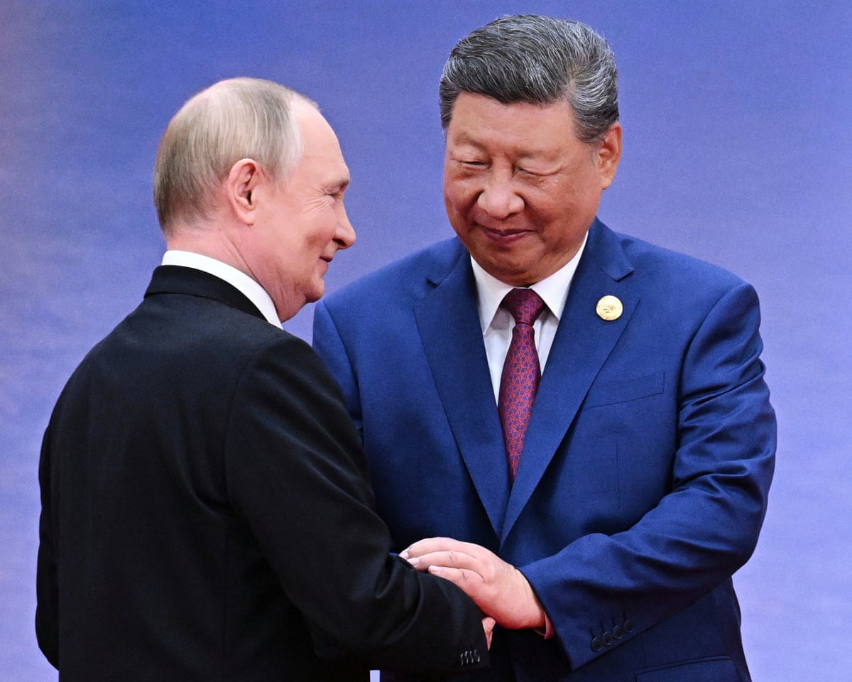 Vladimir Putin and Xi Jinping shake hands