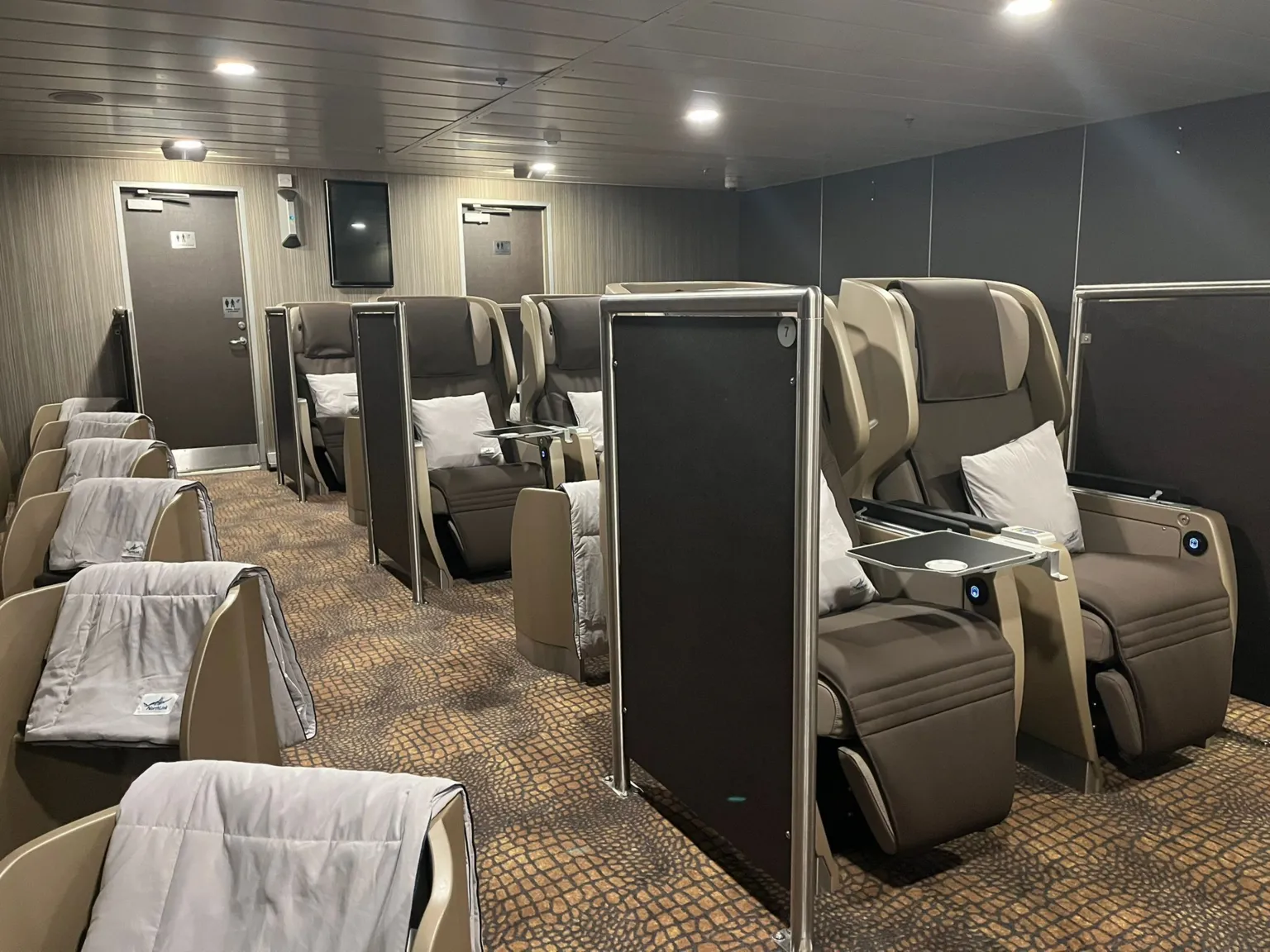 A lounge with a number of reclining sleep pods inside it