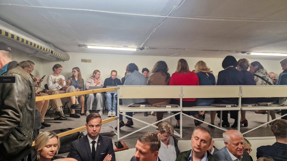 People gather inside a shelter at the Lithuanian parliament after an 'air danger' warning, in Vilnius, Lithuania.