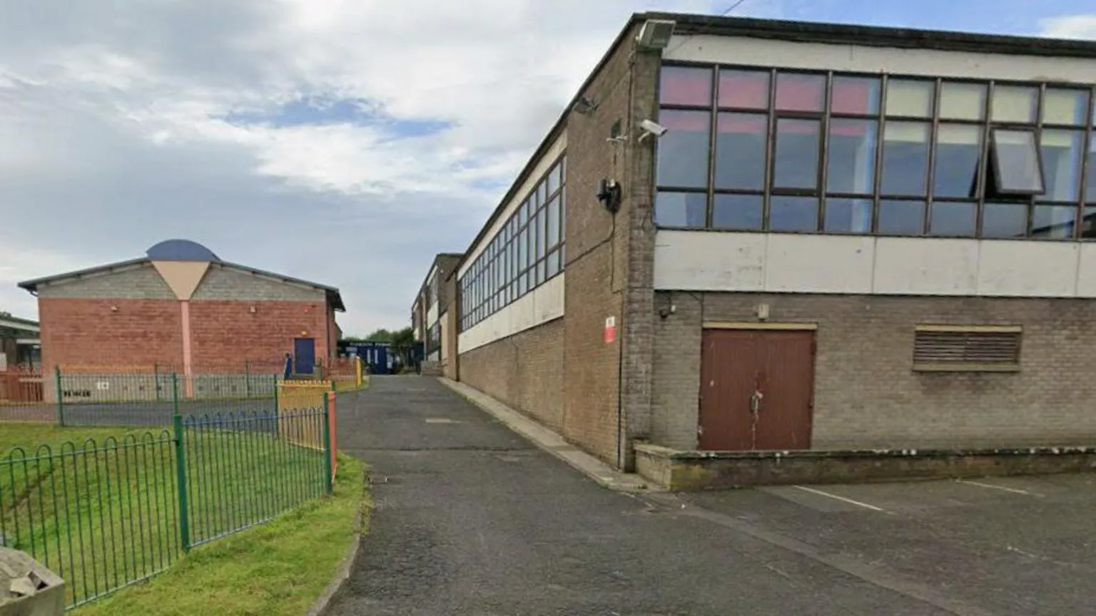 Google An old school building in the Borders with many windows and brick walls and tarmac around it