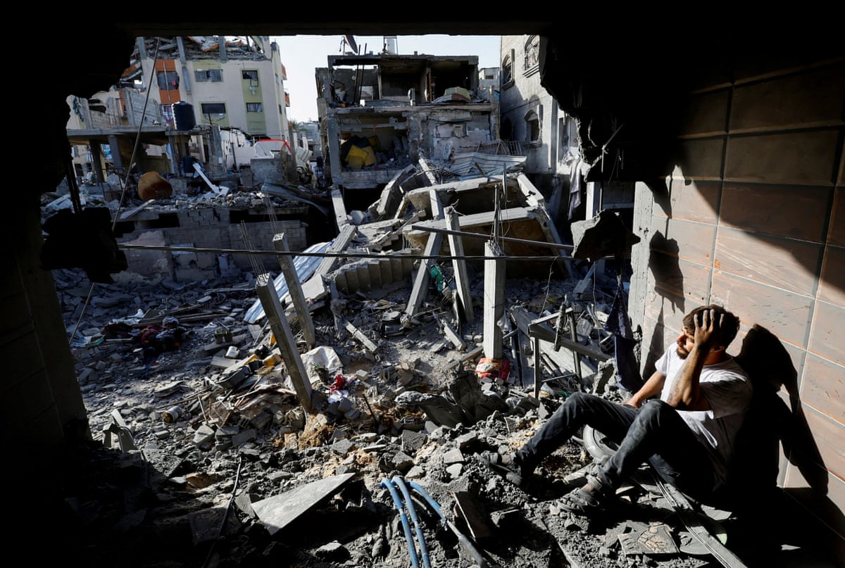 A Palestinian man sits beside the rubble of a house targeted in an Israeli strike in the Bureij refugee camp in the central Gaza Strip.