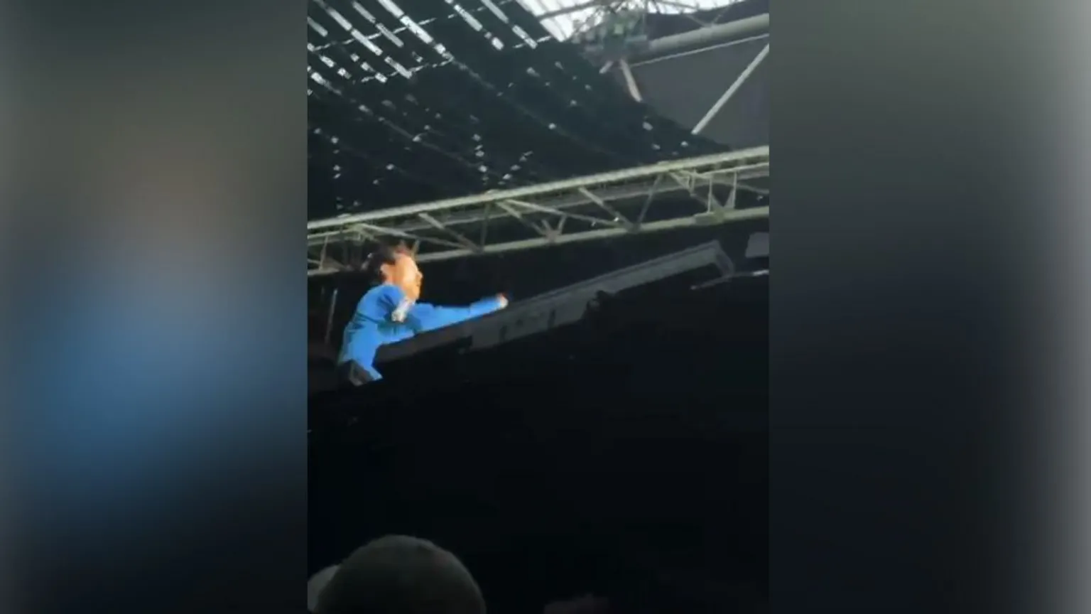 Nadia Wesseling A screengrab of Harry Styles performing on stage, with a high staging partially blocking the view of the star who is wearing blue.