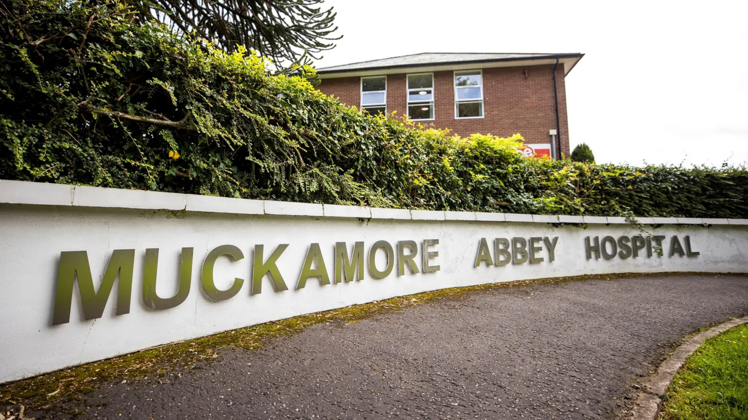 A white wall with silver letters on it reading