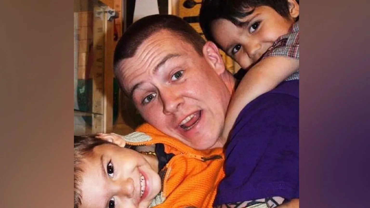 Instagram/Kush Burman An older photo of Kush with his brother Shi and stepdad Matt. It's a close-up photo so you can only really see their faces but all three are looking at the camera and smiling. Matt is in the middle with short dark hair and has a blue t-shirt on, Shi has his arms round his neck in the top right-hand corner as if he's on his back, while Kush's head is turned to the side in the bottom left-hand corner as if he's hanging on to Matt's midriff.
