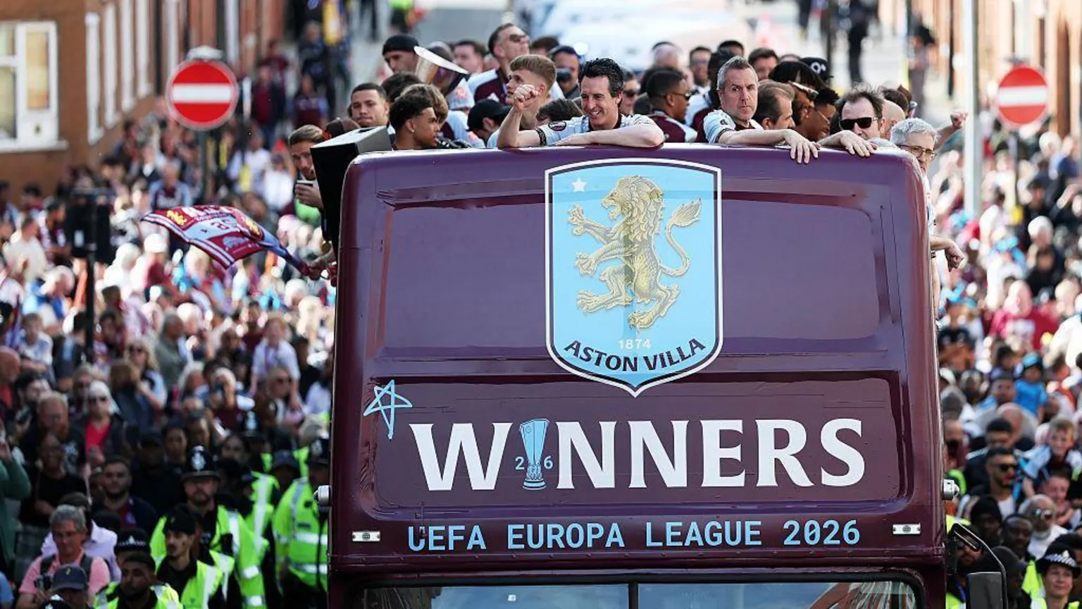 Unai Emery waves to fans from the bus during the victory parade.