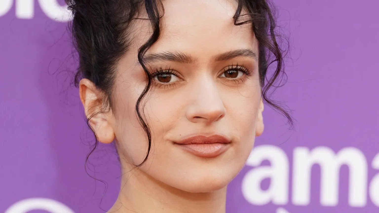 PA A close-up of Rosalia on the red carpet, with strands of curly hair falling down over her face