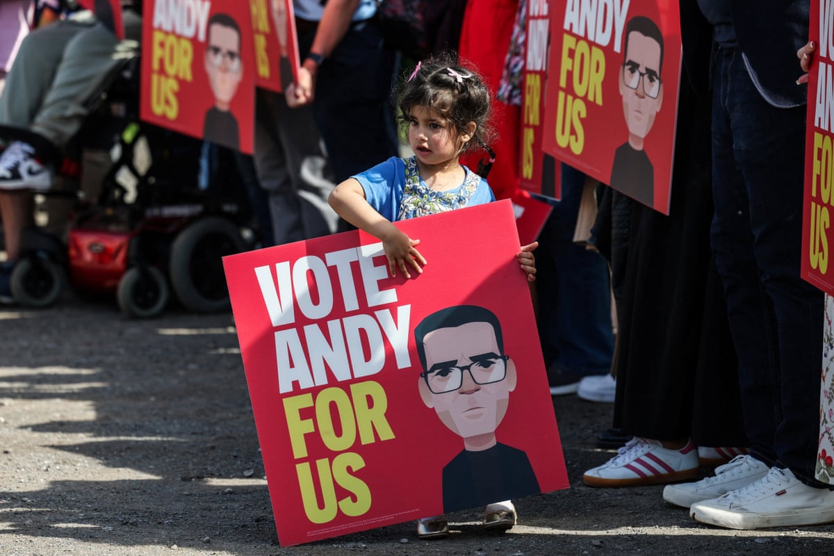 A child carries a placard with a message in support of Greater Manchester mayor and Labour candidate Andy Burnham.