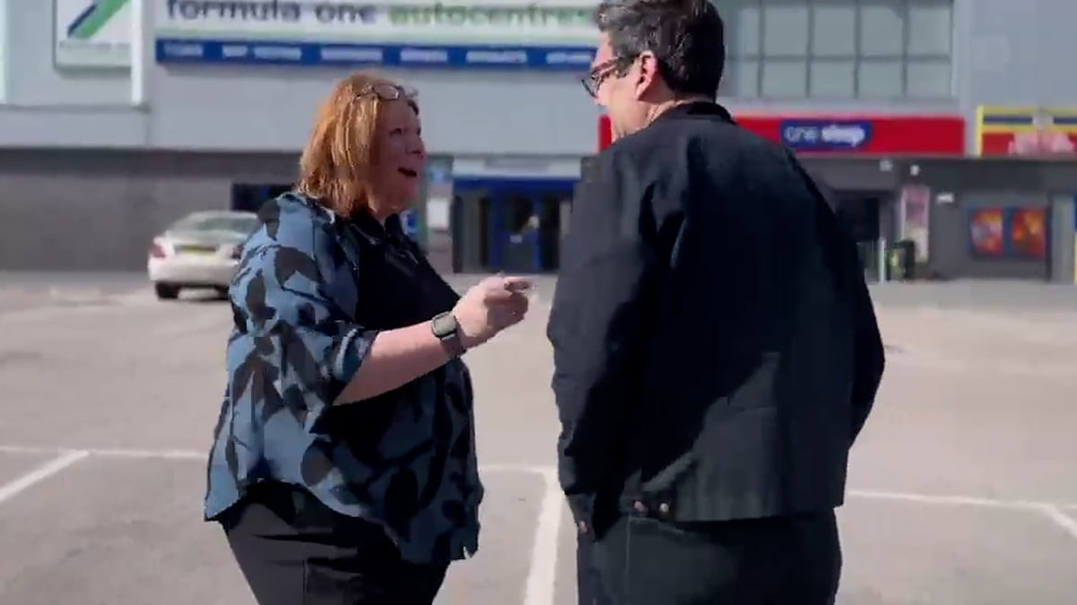 Burnham speaking to a woman in a car park