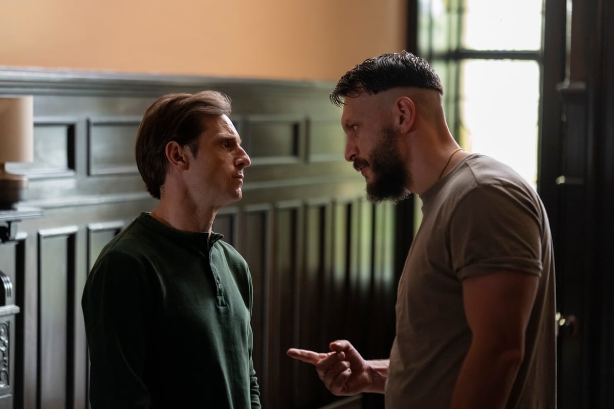 Two men standing facing each other in a wood-panelled room