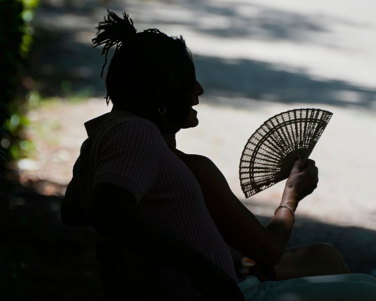 A person rests on a hot day in Retiro Park in Madrid, Spain.
