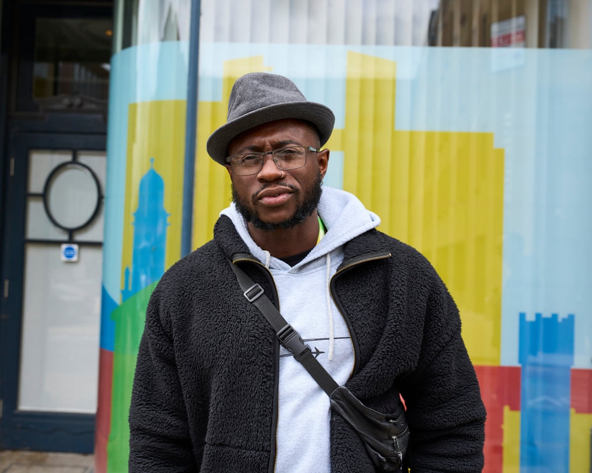 Dare Adekoya wearing hat against colourful backdrop
