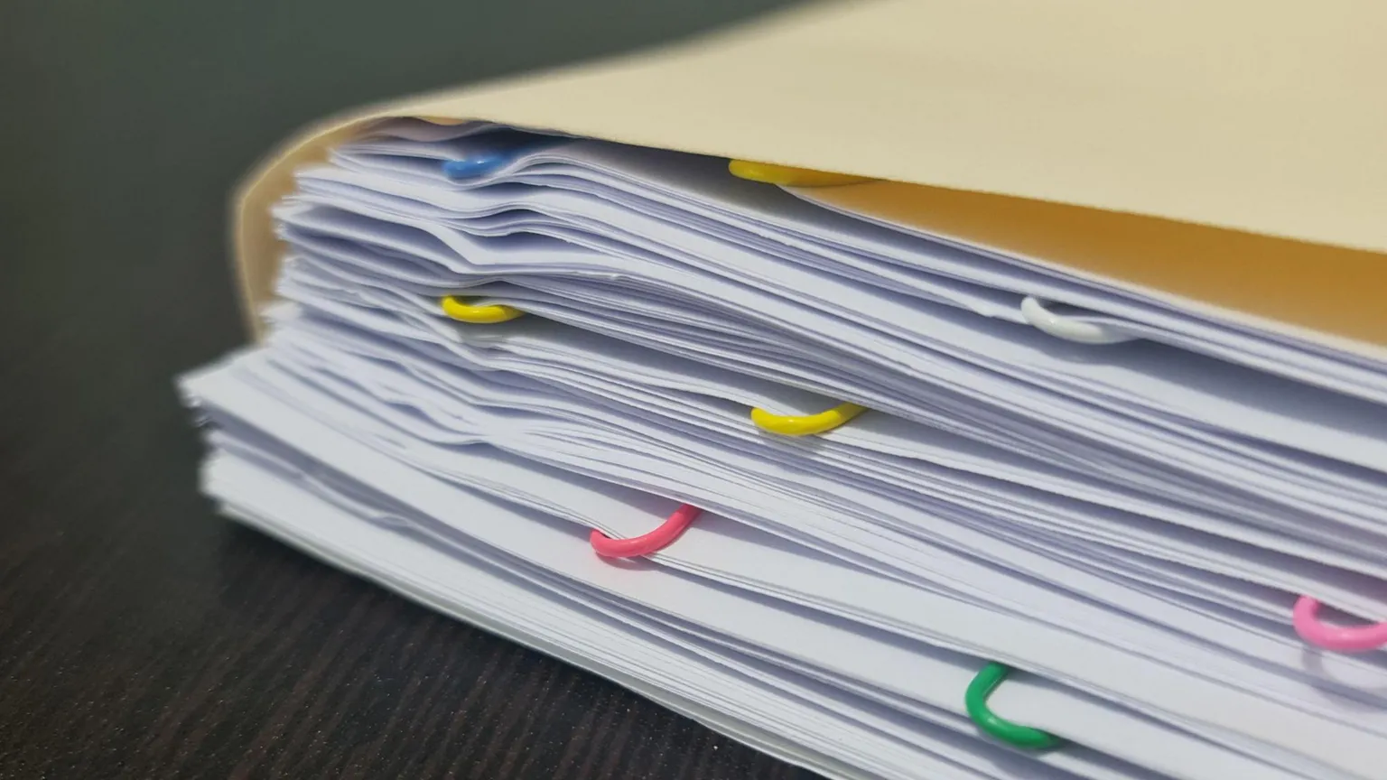  Stacks of white paper with different coloured paper clips 
