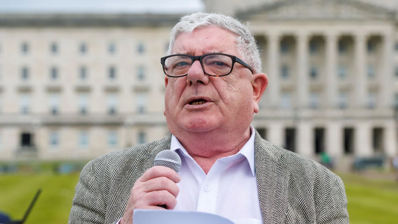 Gerry Murphy speaking. He has grey hair and is wearing a blazer, white shirt and glasses.