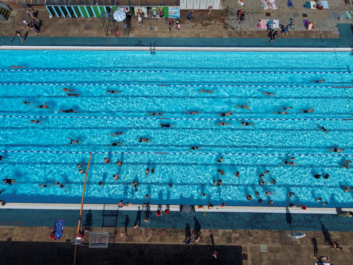 A drone shot showing people swimming in an outdoor pool