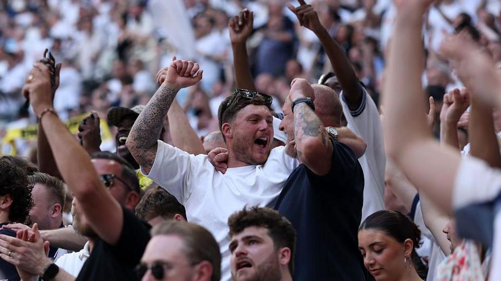 Spurs fans celebrate at the end of the win against Everton that kept them in the Premier League