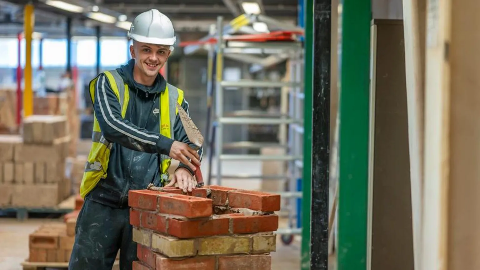 Dumfries and Galloway College A young man in hard hat practices his brick building skills