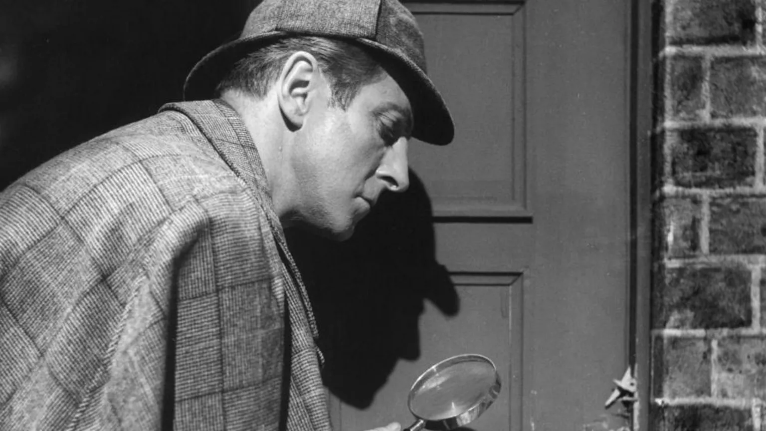  Black and white pic of Sherlock Holmes detective with a magnifying glass